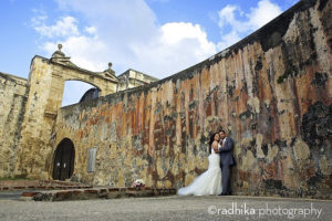 a bride and groom taking wedding photos at san cristobal fort in old san juan