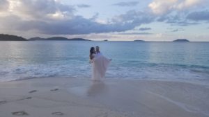 bride and groom on beach at sunset
